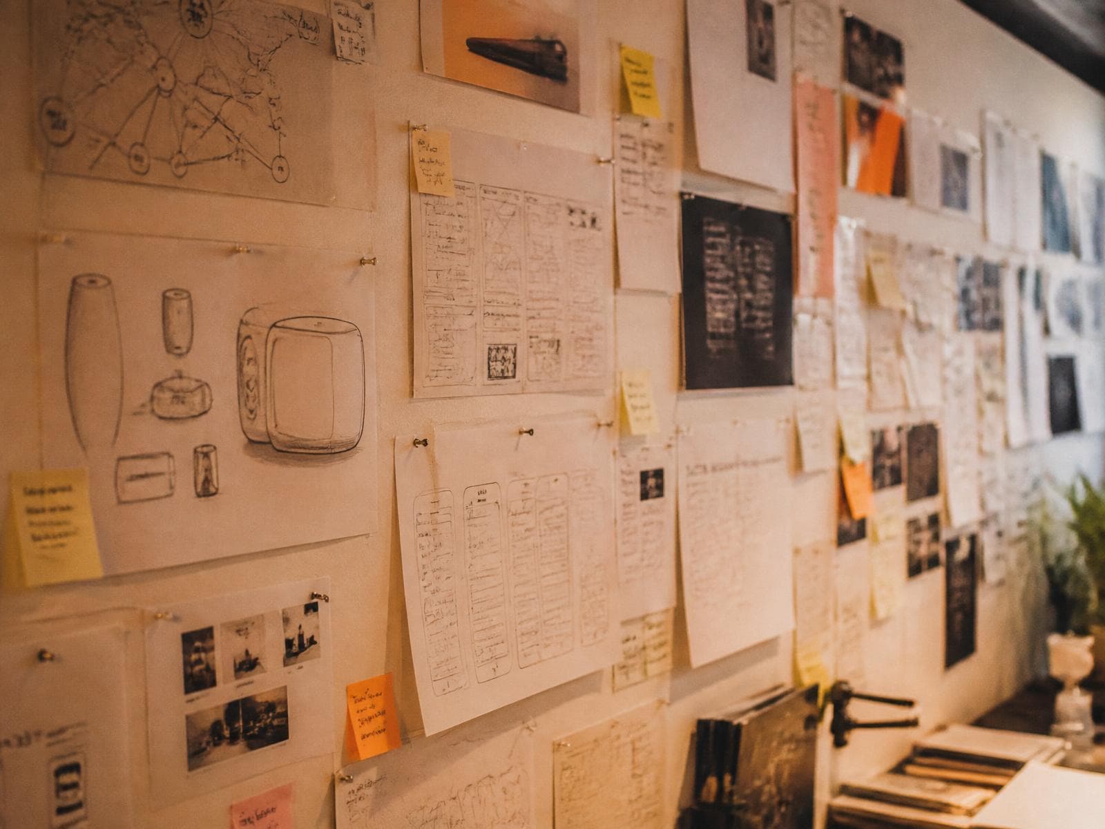 A studio wall of pinned research notes, printed diagrams and reference photography — the visible thinking behind the work.